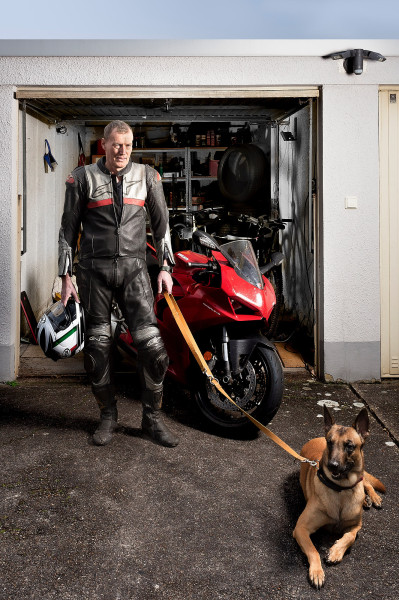 Portrait, Motoradfahrer mit Hund vor garage, Inszeniert, Studioausleuchtung.